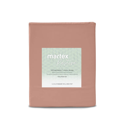 A folded bedding set in a dusty rose pink color, featuring a central white label with the brand name 'martex' and product details for the 'Restore' cotton/tencile blend.
