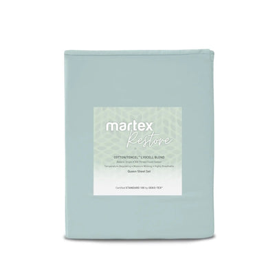 A folded light blue sheet set in a soft dust bag with a white label reading 'martex Restore' on a clean white background.