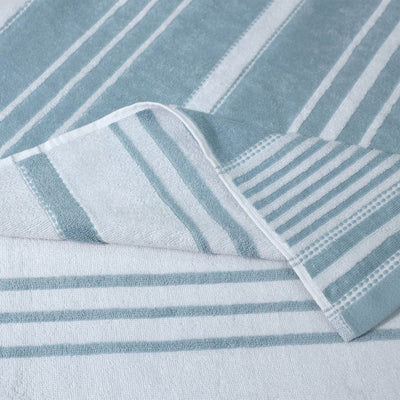 Close-up of a folded towel with mineral and white stripes on a light gray background