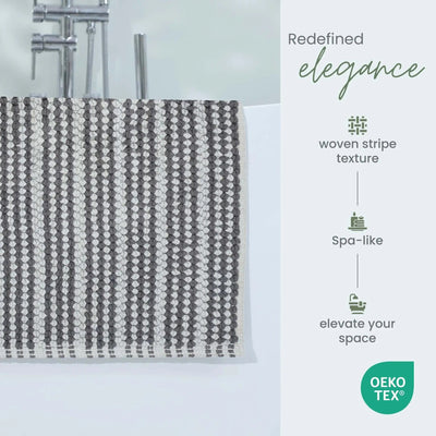 A charcoal bath rug. The right side of the image contains marketing text reading 'Redefined elegance' and feature callouts including 'woven stripe texture,' 'Spa-like,' and 'elevate your space,' with an OEKO-TEX badge at the bottom.