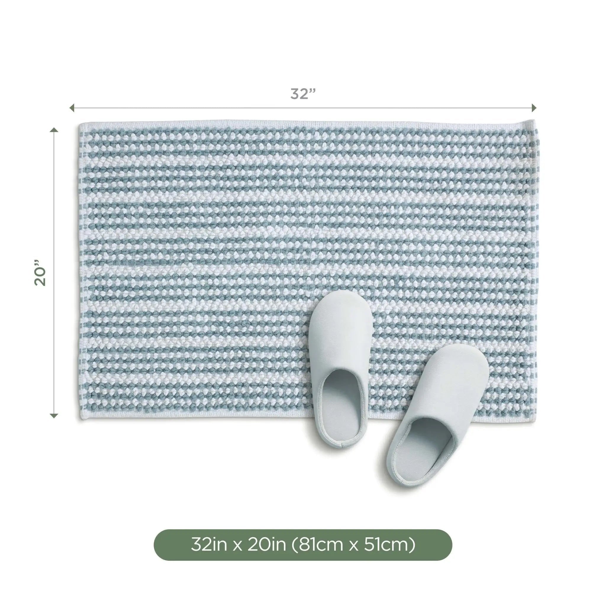 A rectangular mineral bath rug, shown with a pair of white slippers on top. Measurement labels indicate 32 inches by 20 inches, with a green label at the bottom reading 32 in x 20 in (81cm x 51cm).