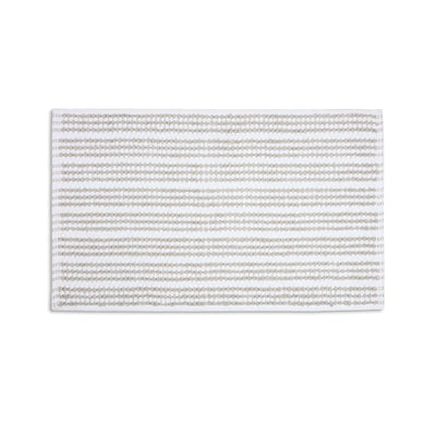 A rectangular sand color bath rug with horizontal stripes, shown flat against a solid white background.