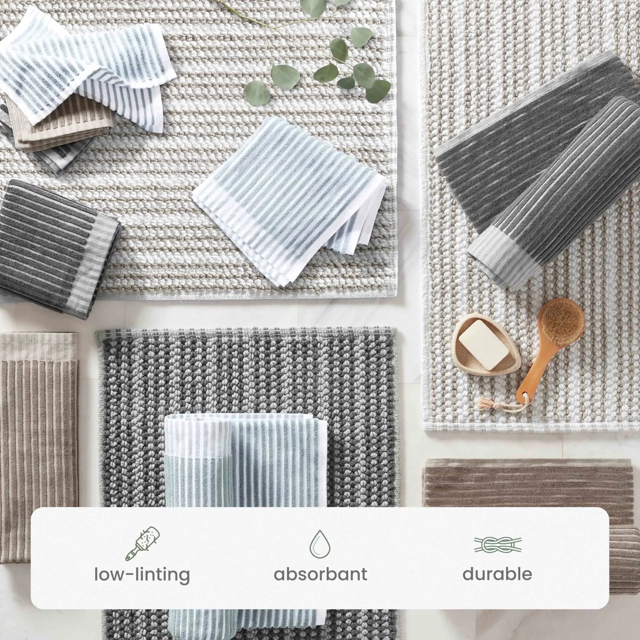A flat-lay product display of textured, low-linting bath rugs on a light marble background with a white informational banner at the bottom detailing product features.