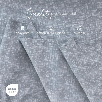 Gray patterned fabric with a subtle woven texture, shown folded with white text overlays reading 'Quality you can feel', 'easy care', 'cotton TENCEL blend', and 'durable', plus an OEKO-TEX certification badge.