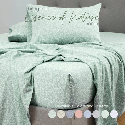 Green patterned bedding set on a bed with a gray headboard.