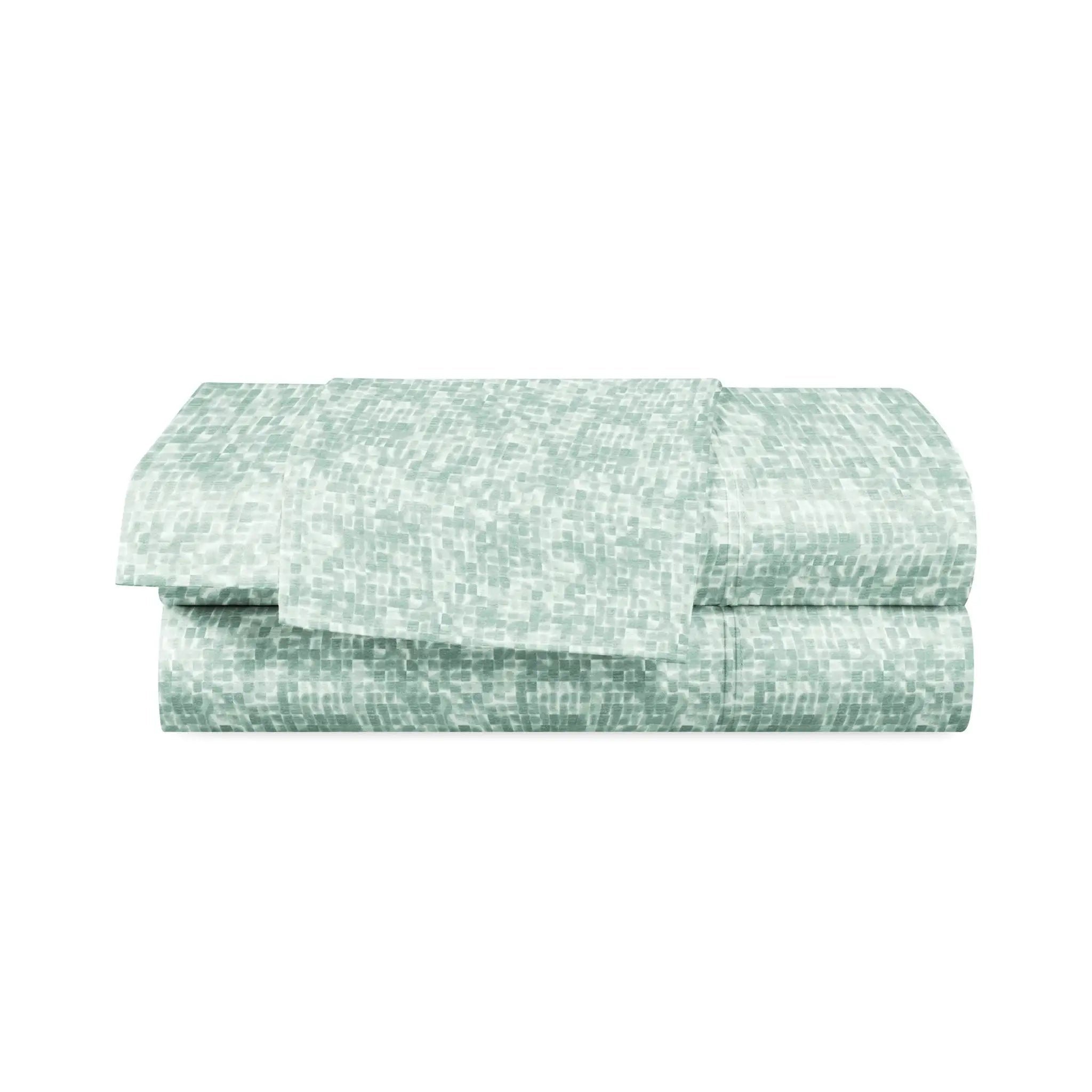 Folded green and white patterned fabric on a white background