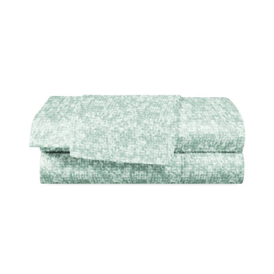 Folded green and white patterned fabric on a white background