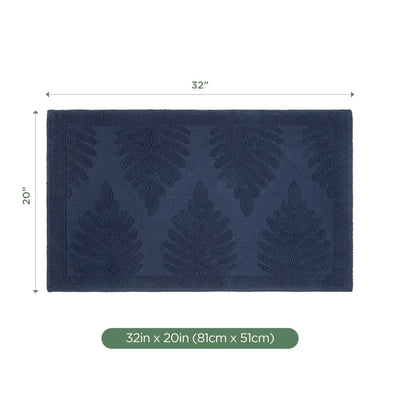 A rectangular navy bath rug with a raised leaf pattern, shown with dimension lines indicating 32 inches by 20 inches, plus a green label at the bottom reading 32in x 20in (81cm x 51cm) on a white background.