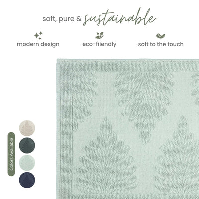 A close-up of a sage bath rug with a leaf pattern, shown on a white background with marketing text and color swatches.