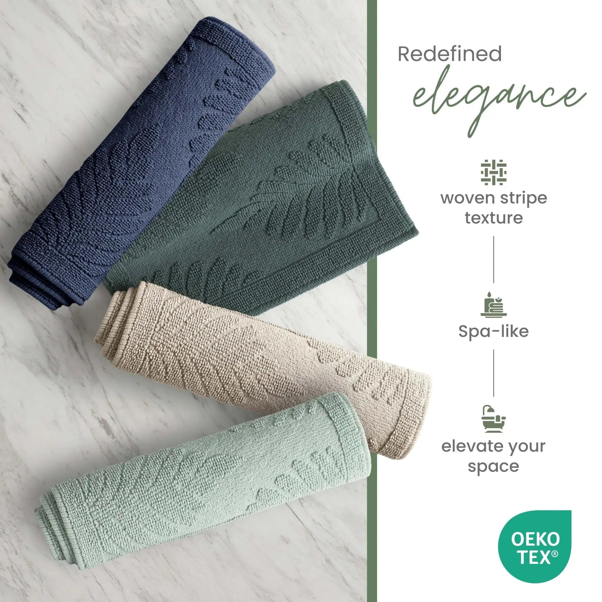 Four rolled bath rugs in navy, sage, sand, and jade are arranged diagonally on a light marble surface, with text on the right describing the woven stripe texture, spa-like feel, and OEKO-TEX certification.