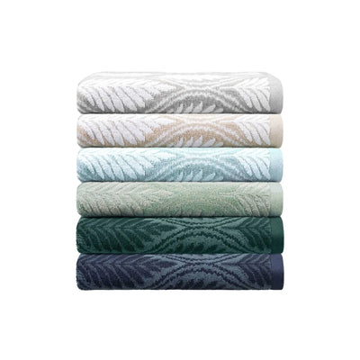 A stack of six folded bath towels with a textured leaf pattern, shown in a gradient of colors from light gray and white to sage green, teal, forest green, and navy blue, on a solid white background.