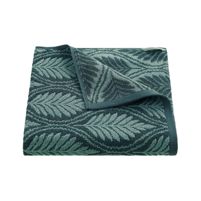 Folded jade bath towel with leaf pattern on a white background