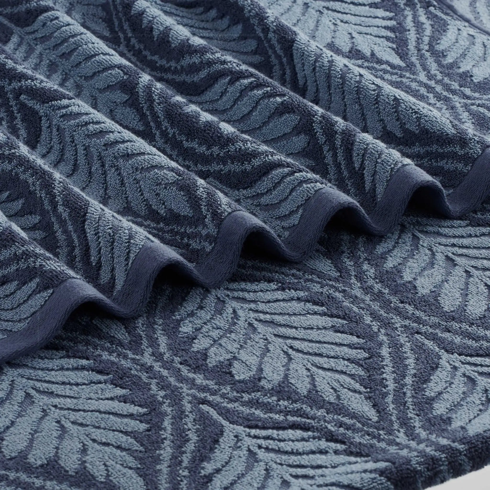 Close-up of a textured navy fabric with leaf pattern