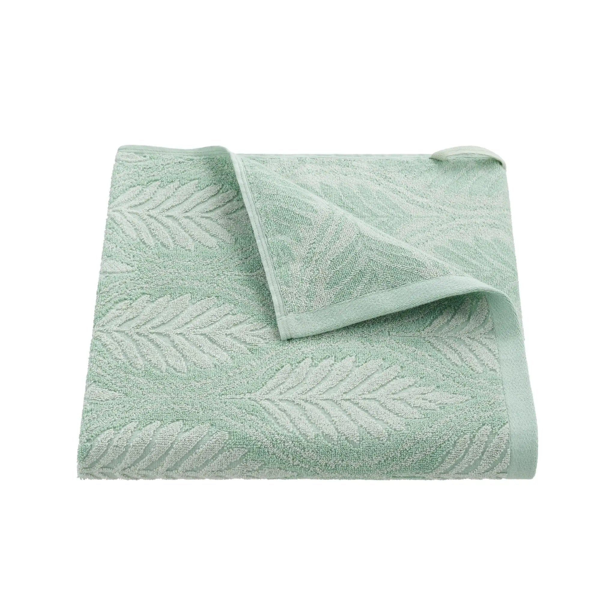 A folded light green bath towel with a raised leaf pattern, shown on a plain white background.