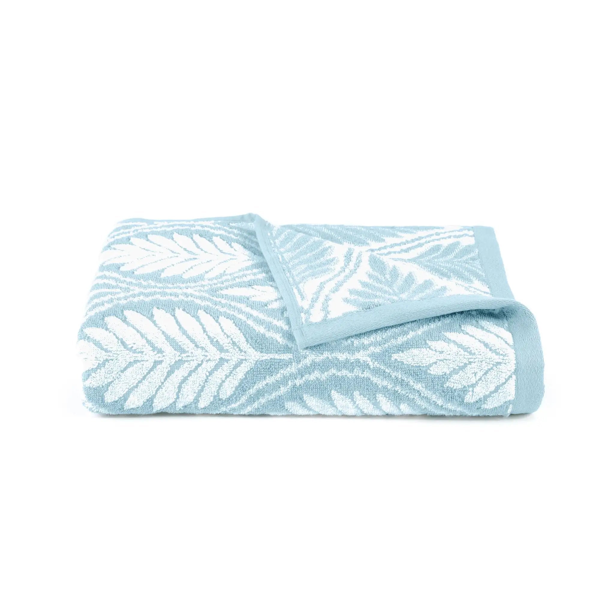 A folded light blue and white patterned bath towel with a leaf design, shown on a plain white background.