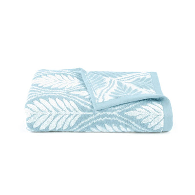 A folded light blue and white patterned bath towel with a leaf design, shown on a plain white background.