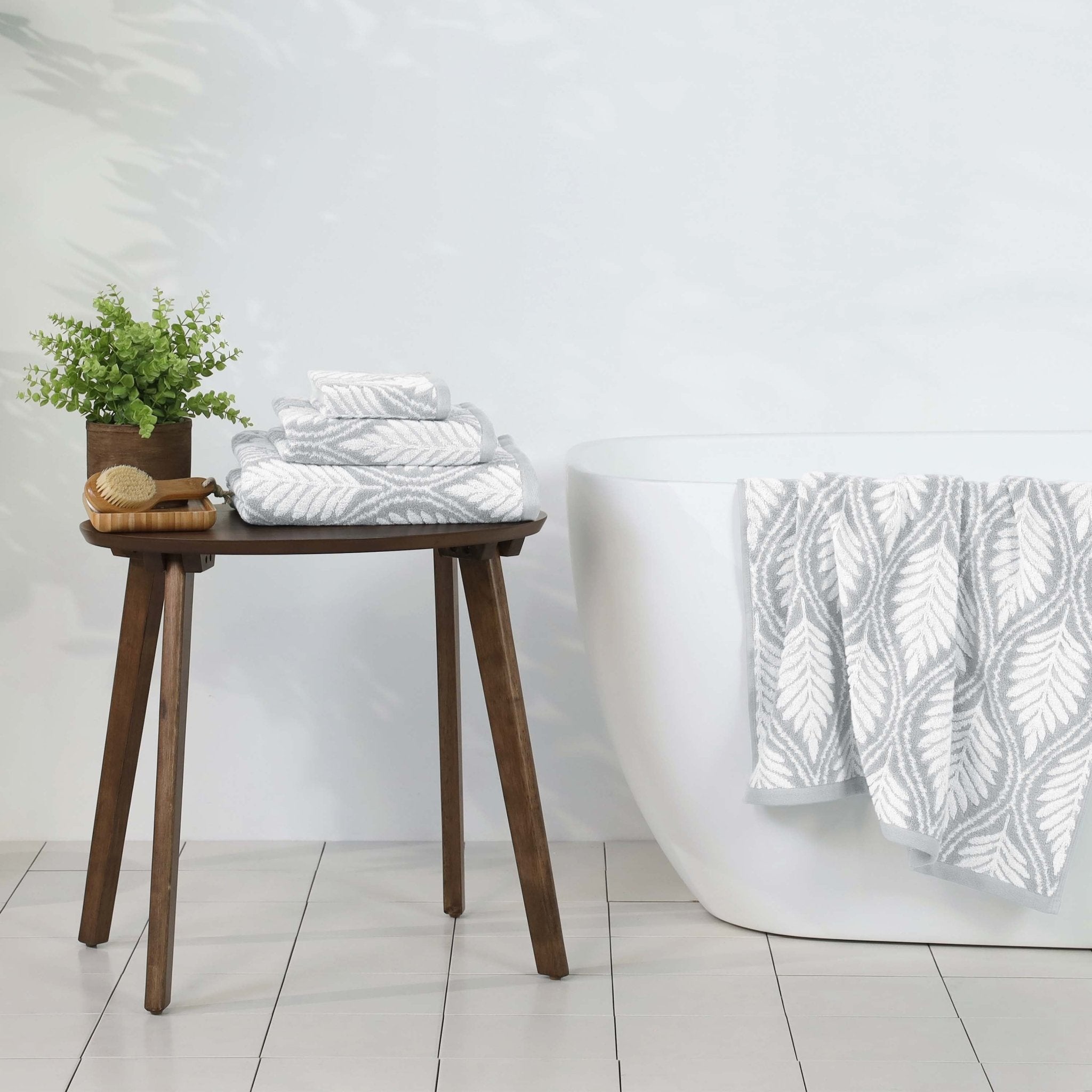 Bathroom setting with grey towels on a wooden stool.