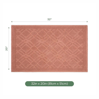 A rectangular bath rug in a clay color with a raised geometric diamond pattern, shown with dimension lines indicating 32 inches by 20 inches on a white background.
