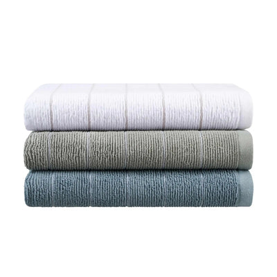 Three folded towels stacked horizontally on a white background, in white, gray, and blue colors with a ribbed texture.