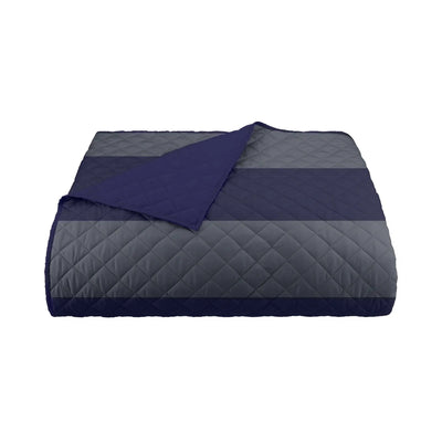 Quilted coverlet with navy and gray pattern on a white background