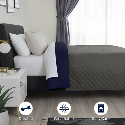Bed with gray coverlet and folded navy reversible