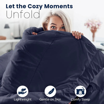 Woman hugging a large navy comforter with text 'Let the Cozy Moments Unfold' and icons indicating 'Lightweight', 'Gentle on Skin', and 'Comfy Sleep'.