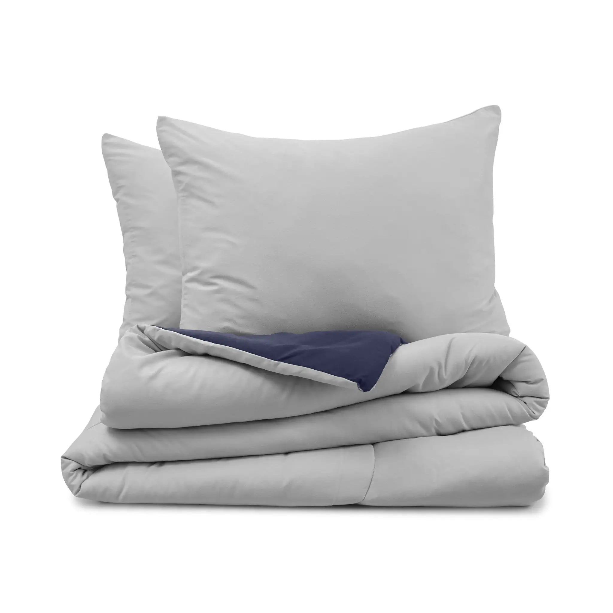 Light gray comforter and two matching pillow shams, with a navy reverse side, set against a plain white background.