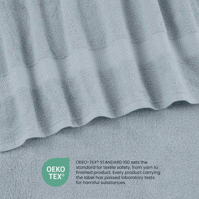 A close-up of a soft blue textured fabric, likely a towel or blanket, with a wavy patterned edge and an OEKO-TEX certification label at the bottom left.