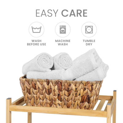 Basket with rolled white towels and washing instructions on a white background