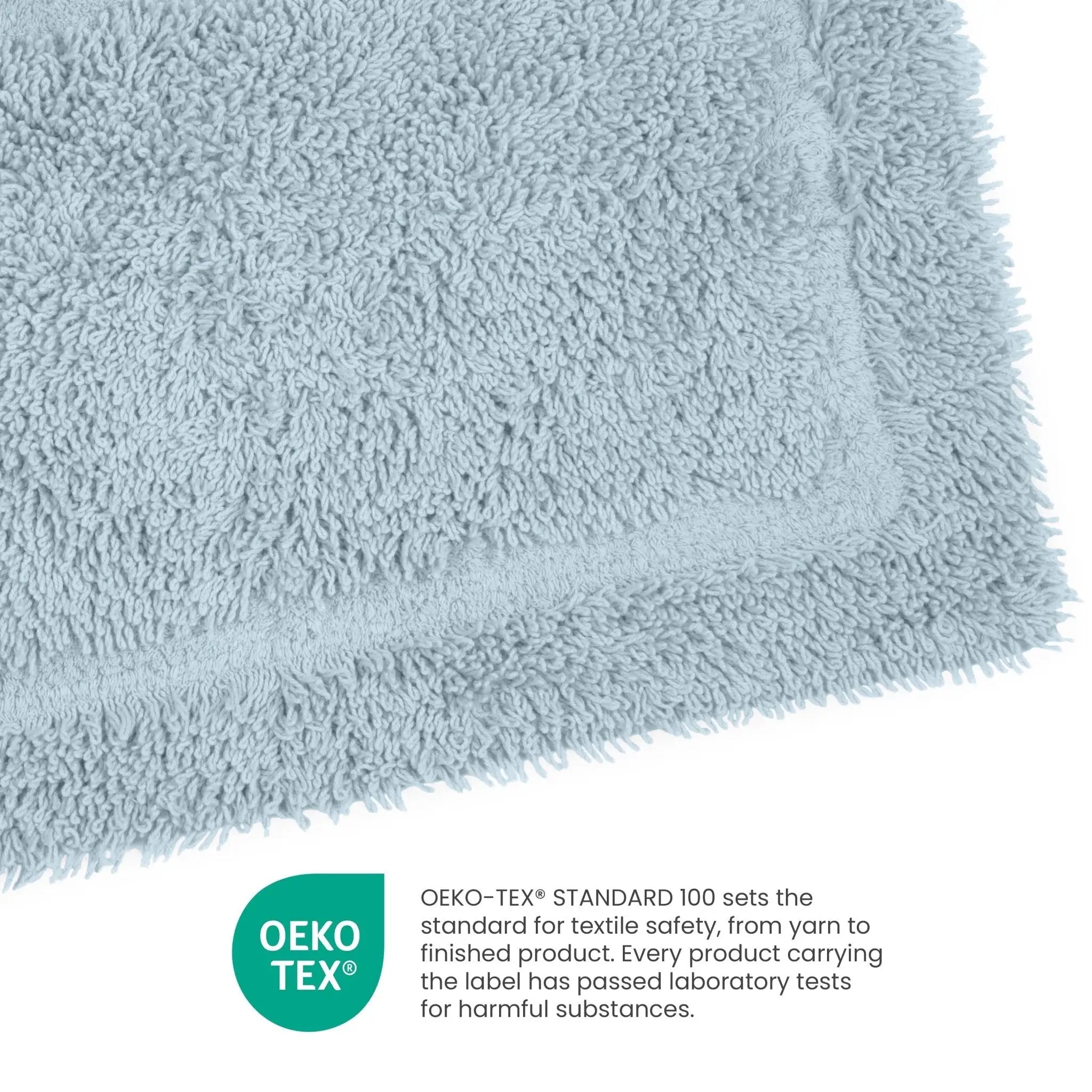 A close-up of a light blue plush terry cloth fabric corner with an OEKO-TEX certification badge and text explaining textile safety, on a white background.