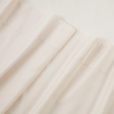 A close-up of draped off-white or cream-colored fabric with soft folds and a smooth texture.