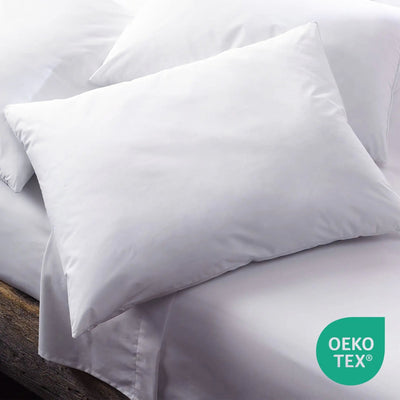 White pillow on a bed with Oeko-Tex logo in the corner