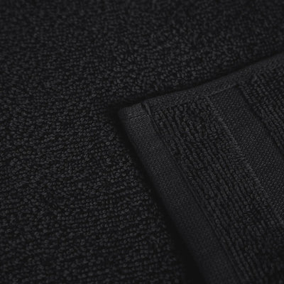 Close-up of a black textured fabric product, showing a looped terry surface and a folded ribbed edge.