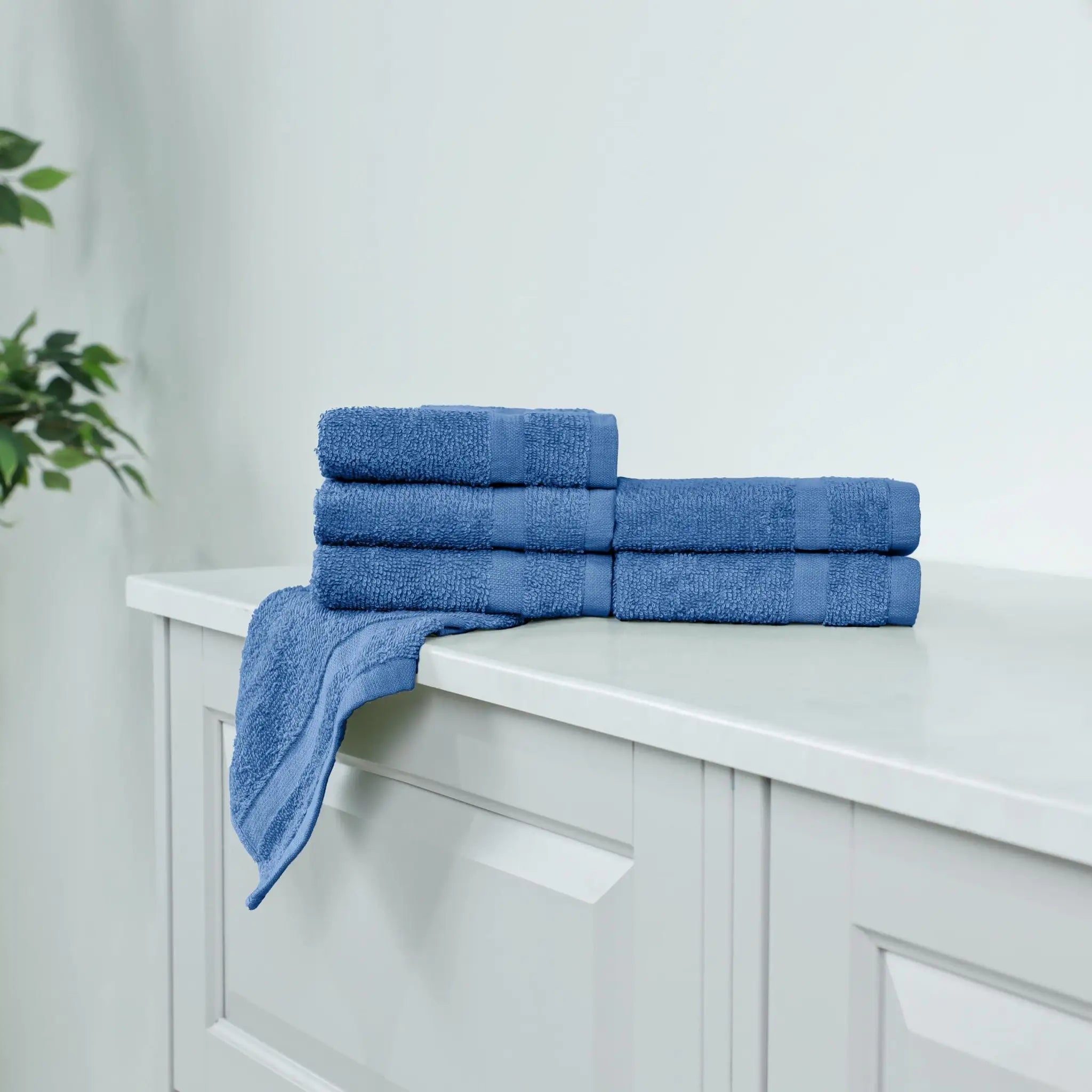 Set of blue washcloths on a white cabinet.