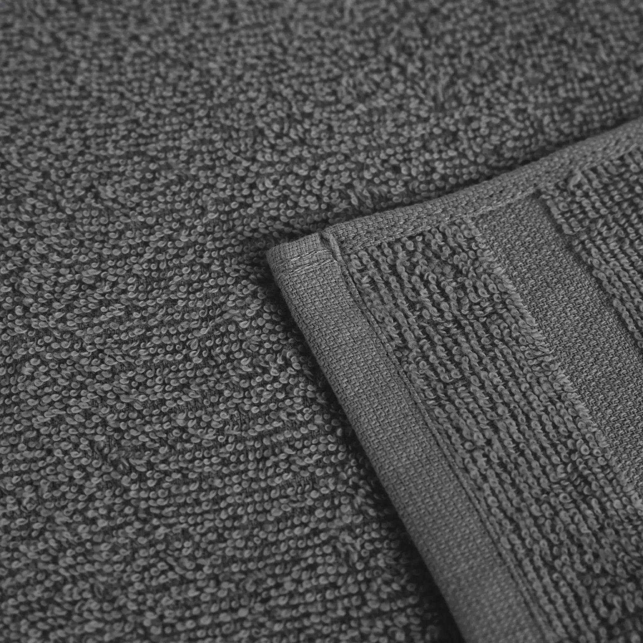 Close-up of a charcoal textured fabric with a folded corner showing a ribbed terry edge.