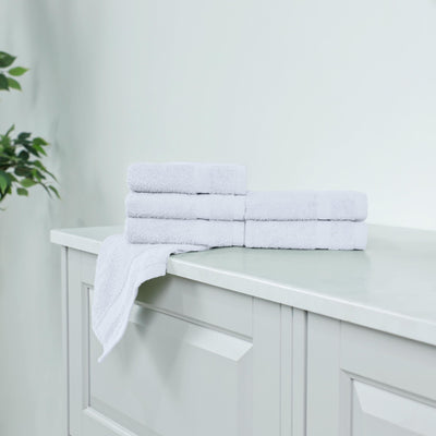 Stack of white washcloth on a white cabinet.