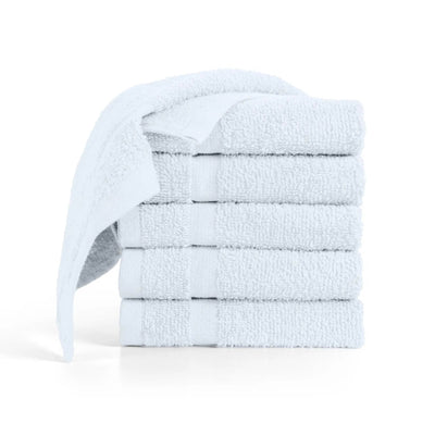 A stack of five folded white washcloths with one washcloth draped over the side.
