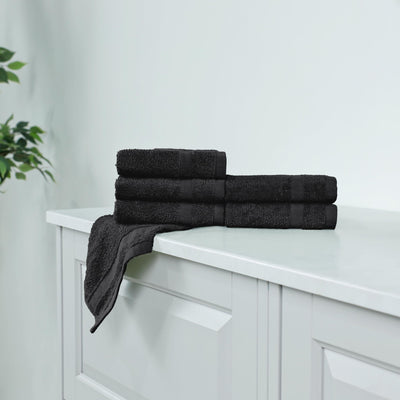 Stack of black washcloth on a white cabinet.