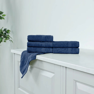 Stack of navy washcloths on a white cabinet.