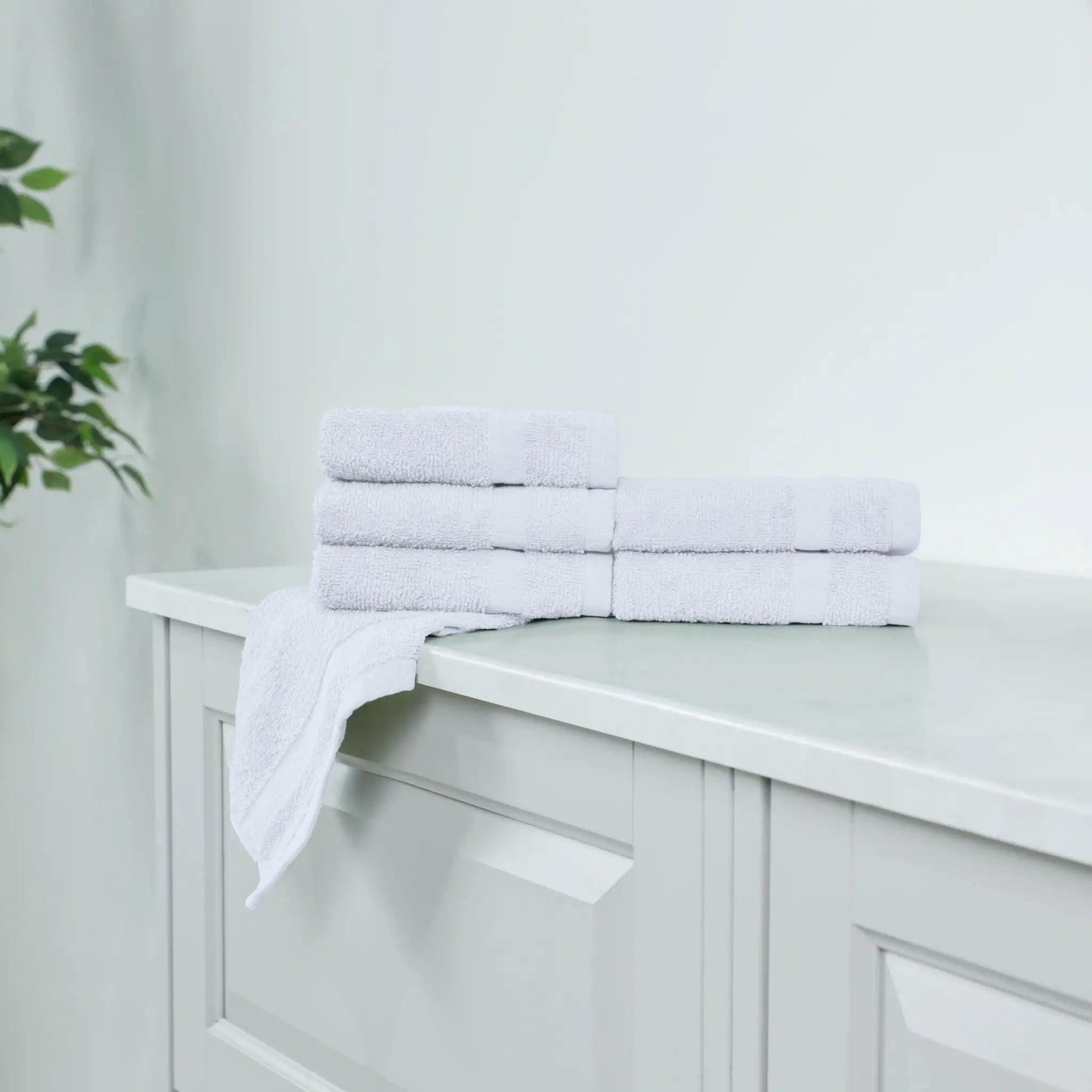 White washcloths on a white cabinet.