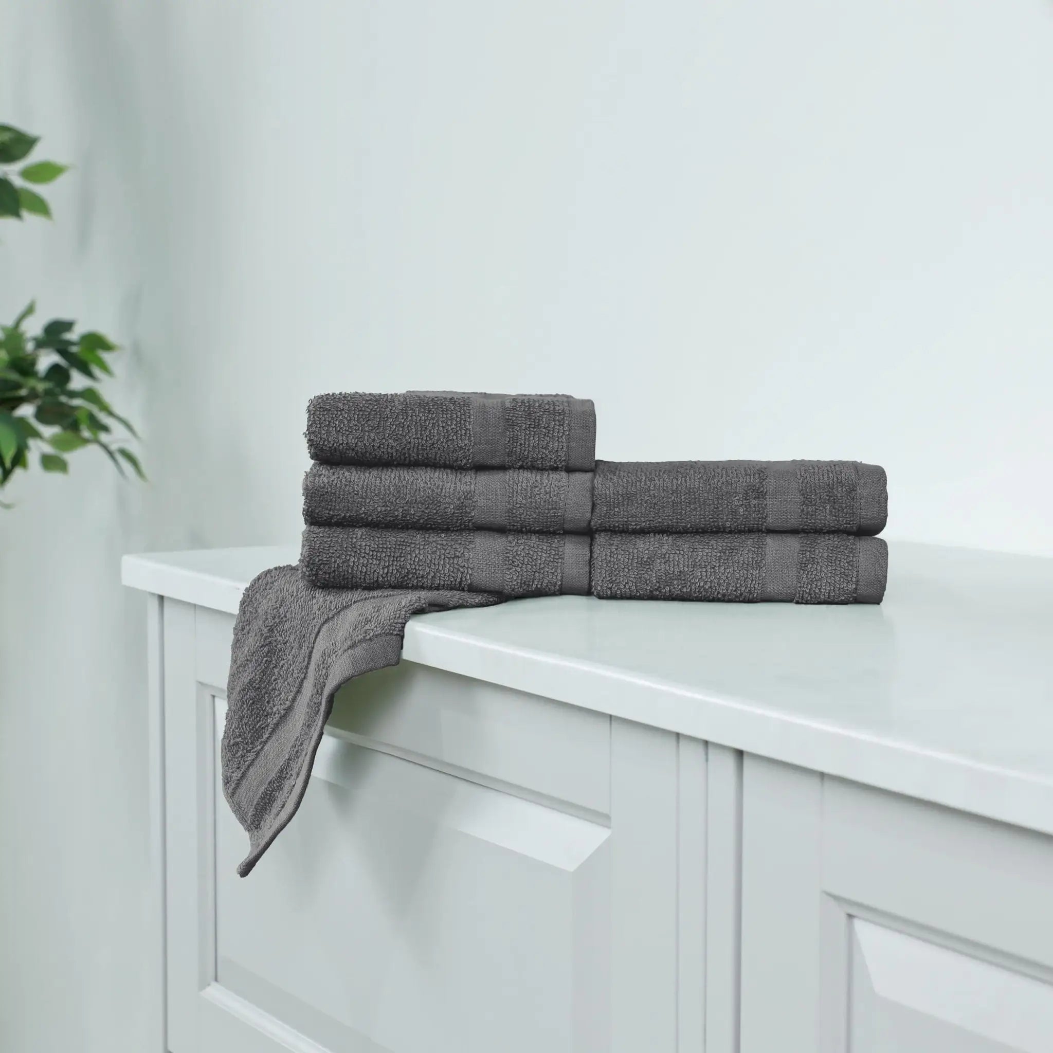 Stack of charcoal washcloths on a white cabinet.