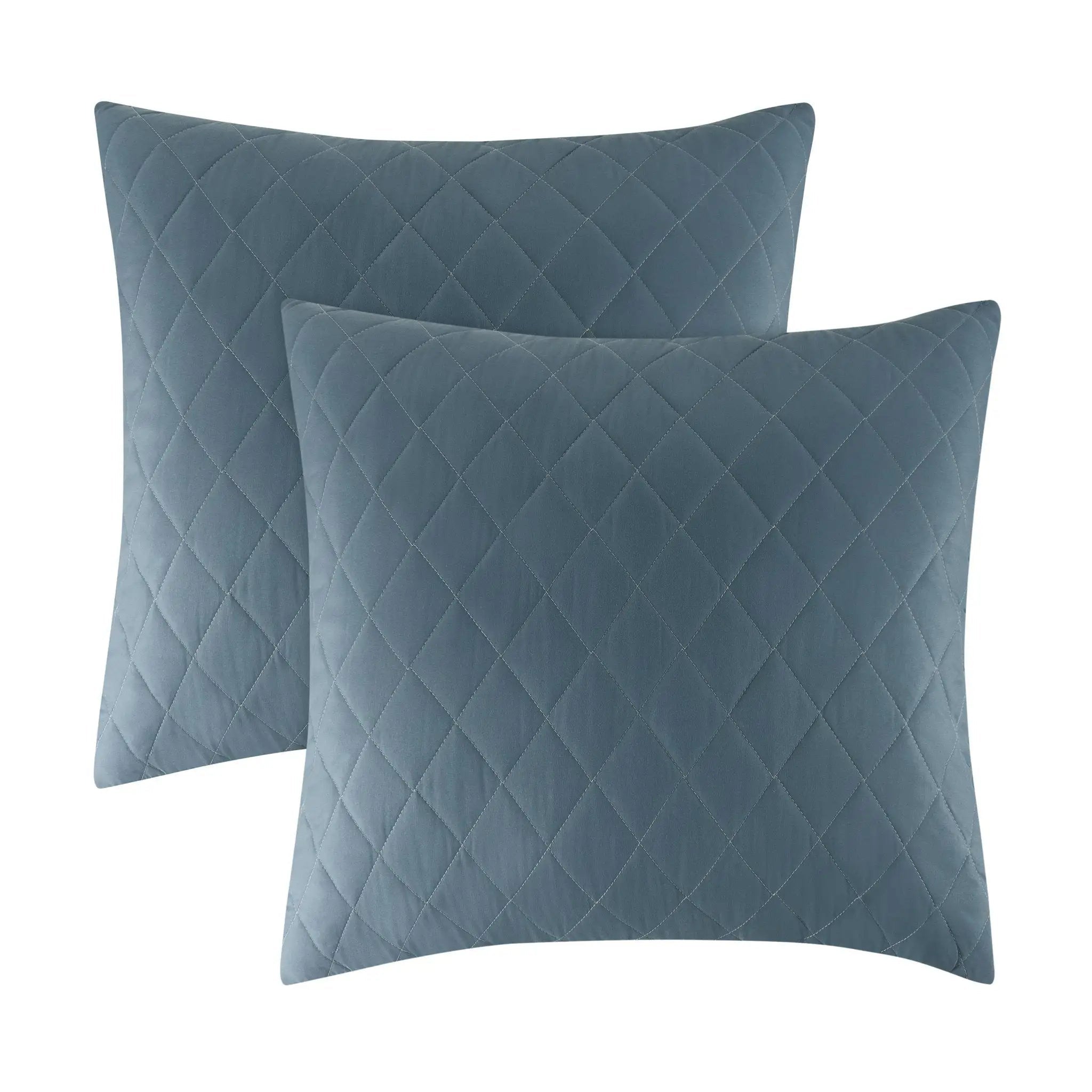 Two square quilted throw pillows in a muted slate blue color, arranged with one slightly behind the other on a plain white background.