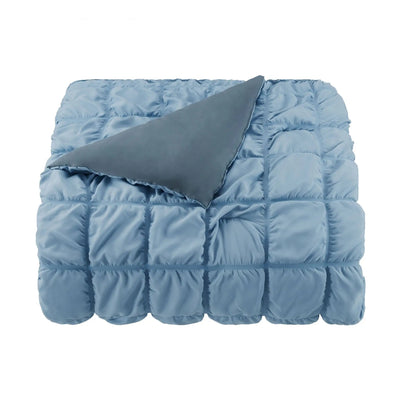 Blue quilted comforter on a white background