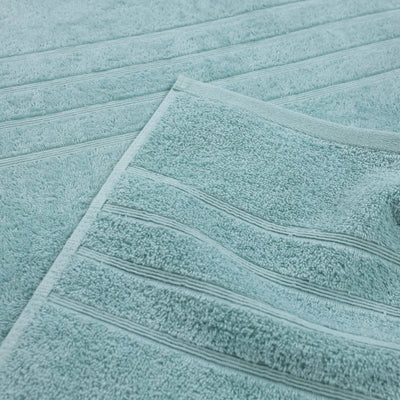 A close-up of a mineral bath towel with horizontal ribbed stripes, layered over another matching towel.