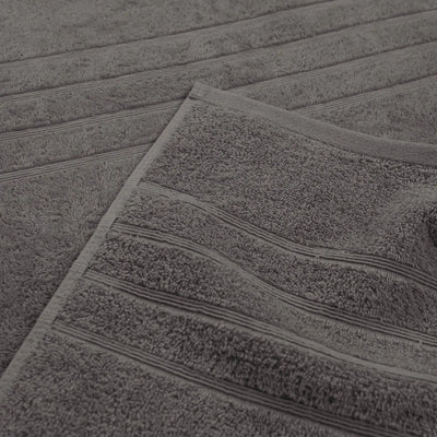 A close-up of a charcoal textured bath towel with horizontal ribbed stripes, showing its soft terry cloth texture.