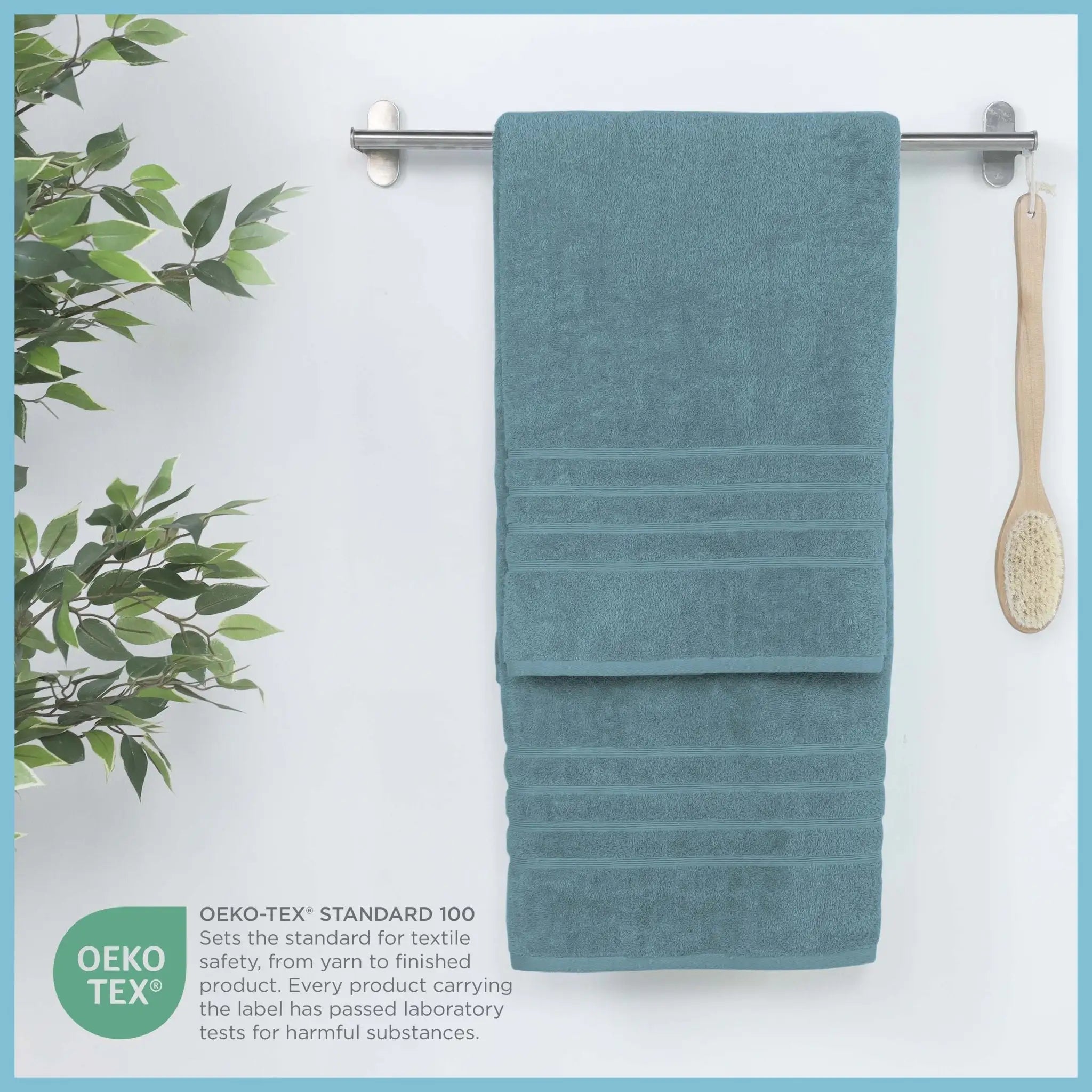A teal blue bath sheet hangs from a metal towel bar on a white wall. An OEKO-TEX certification badge and text appear in the lower left corner.