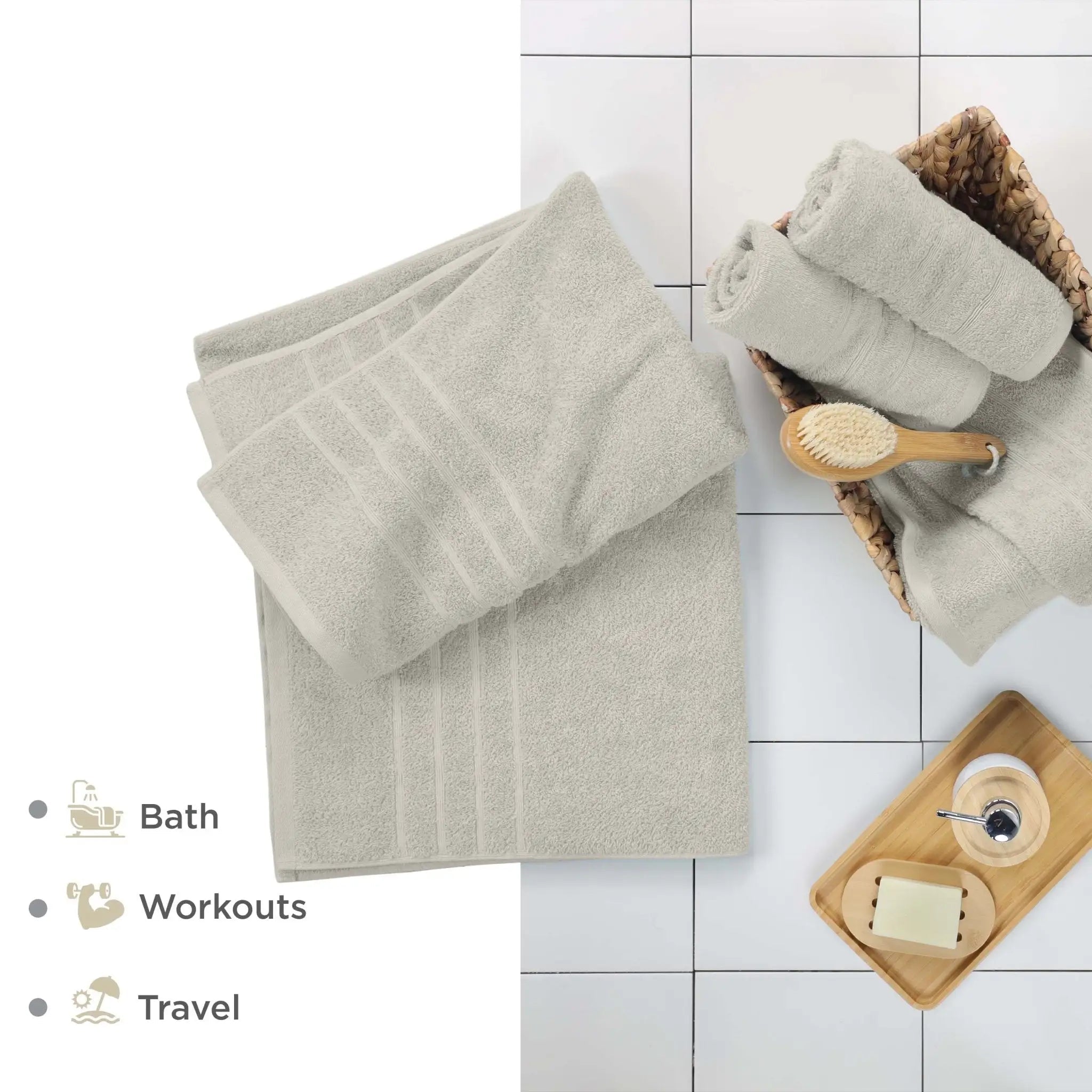 Sand-colored bath sheets and bathroom accessories on a tiled floor