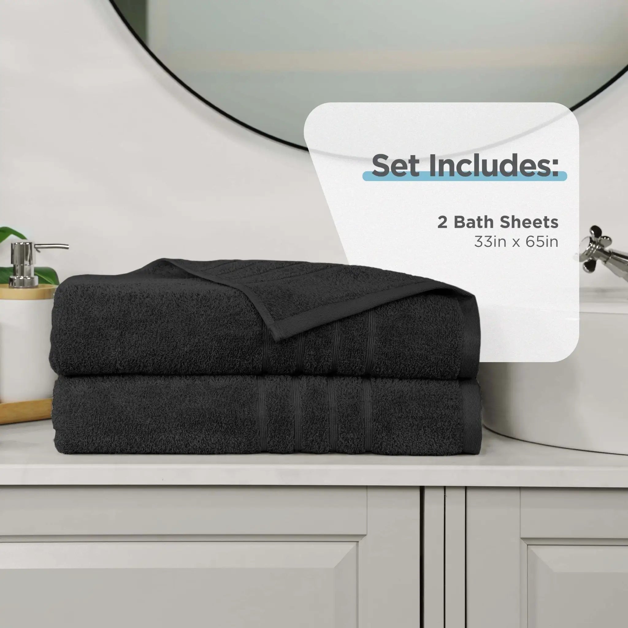 Two folded black bath sheets stacked on a white bathroom vanity, with a white overlay card reading 'Set Includes: 2 Bath Sheets 33in x 65in'.
