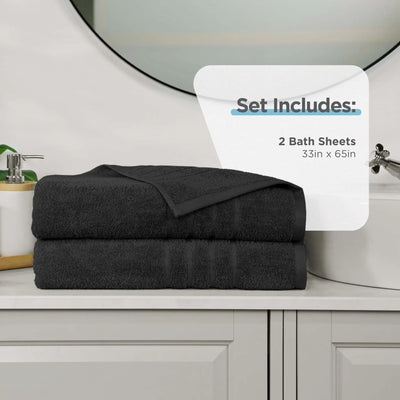 Two folded black bath sheets stacked on a white bathroom vanity, with a white overlay card reading 'Set Includes: 2 Bath Sheets 33in x 65in'.
