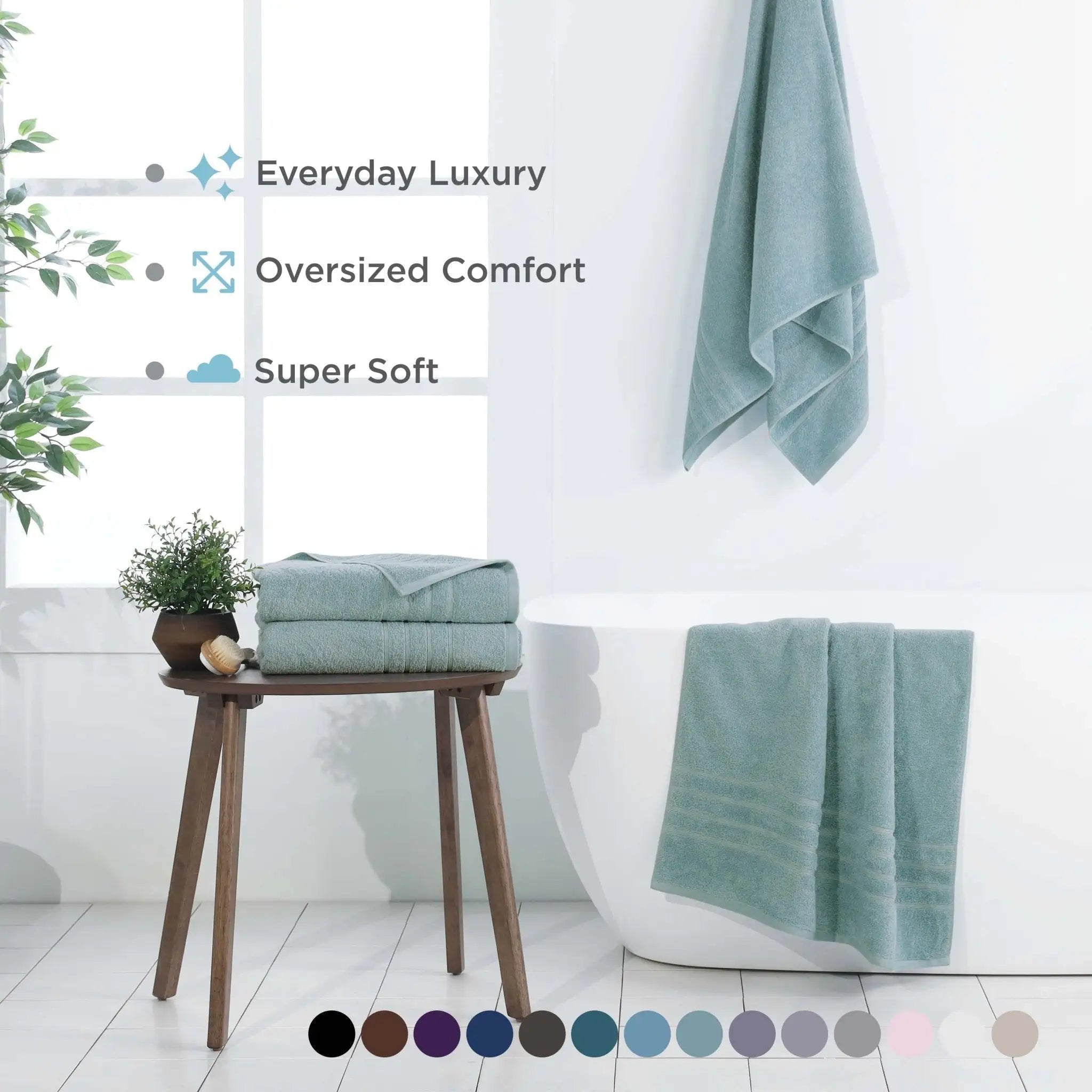 A set of soft, mineral colored bath sheets, set in a bright, modern bathroom. Text overlays highlight key features like 'Everyday Luxury', 'Oversized Comfort', and 'Super Soft', with a color swatch circle graphic at the bottom.